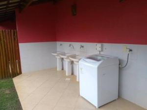 uma casa de banho com quatro lavatórios e uma fila de WC em Imbassai - Casa Alto Padrão completa - Condominio Fechado - A2B3 em Imbassaí