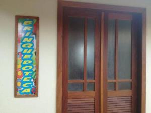 a wooden door with a sign on a wall at Imbassai - Casa Alto Padrão completa - Condominio Fechado - A2B3 in Imbassai