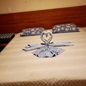 uma cama com um coração feito de luvas brancas em Imbassai - Casa Alto Padrão completa - Condominio Fechado - A2B3 em Imbassaí