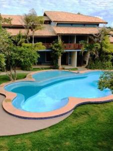 uma grande piscina em frente a uma casa em Imbassai - Casa Alto Padrão completa - Condominio Fechado - A2B3 em Imbassaí