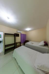 a hotel room with two beds and a window at Pousada Jardim Brasília in Brasilia