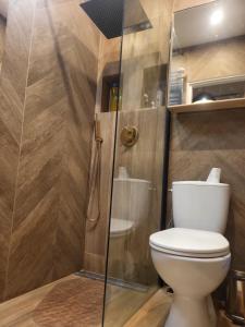 a bathroom with a toilet and a glass shower at Studio Żelazna - Apartment near Old Town in Warsaw