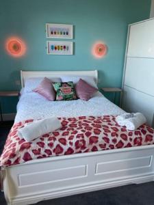 a bedroom with a bed with a red comforter at "The Parlour" Seafront Apartment in Eastbourne