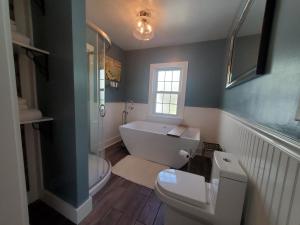 a bathroom with a tub and a toilet and a sink at Vandiver Inn in Havre de Grace