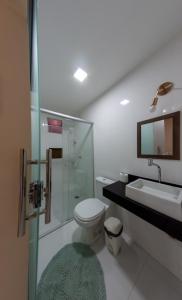 a bathroom with a toilet and a sink and a shower at Pousada Jardim Brasília in Brasilia