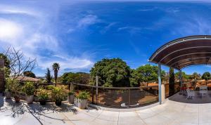 a patio with trees and a blue sky at Pousada Jardim Brasília in Brasilia