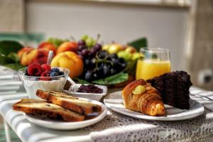 - une table avec des assiettes de produits pour le petit-déjeuner et des fruits dans l'établissement LE MAIOLICHE - Apulian B&B, à Grottaglie