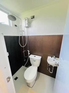 a bathroom with a toilet and a sink at London Unit Tagaytay Wifi/Netflix/Parking in Tagaytay