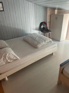 Bett in einem Zimmer mit einer Holzwand in der Unterkunft La belle Vendéenne in La Tranche-sur-Mer