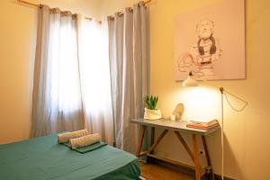 een slaapkamer met een bed, een tafel en een raam bij Exis Suite in Athene