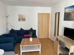ein Wohnzimmer mit einem blauen Sofa und einem Tisch in der Unterkunft TOP Lage in Rostock 3 Zimmer Wohnung mit bestem Ausblick im 1 OG rechts in Rostock
