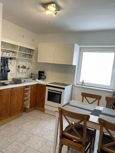 une cuisine avec des appareils blancs et une table avec des chaises dans l'établissement TOP Lage in Rostock 3 Zimmer Wohnung mit bestem Ausblick im 1 OG rechts, à Rostock