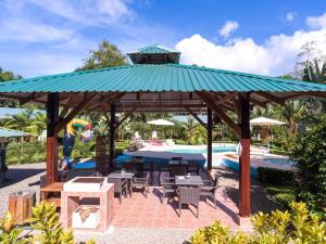 un pabellón con mesas y sillas junto a una piscina en New Caribe Point en Cahuita
