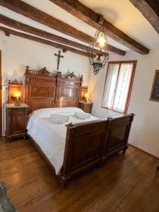 Un dormitorio con una cama de madera con una cruz. en Villa sulle colline del Prosecco - Casa di Gaia, en Follina
