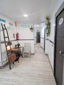 a hallway with a table and a chair and a ladder at Hostal Boutique Luna de Gavín in Cullera