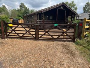 a wooden gate in front of a house at Cheerful 3-bedroom cabin with hot tub in Kings Lynn