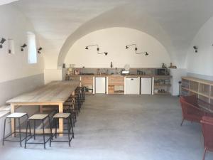 cocina grande con mesa de madera grande y sillas en La Grande Maison, en Montmeyran
