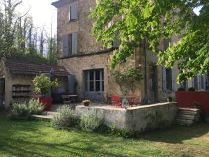 a building with a yard with tables and chairs at La Grande Maison in Montmeyran