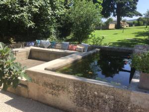 a koi pond in a garden with a lawn at La Grande Maison in Montmeyran