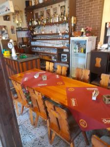 un restaurante con mesa de madera y sillas y un bar en Penzion Krušnohorka, en Tatrovice