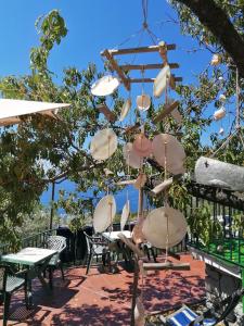 una lámpara de araña hecha de conchas colgando de un árbol en Perla del Levante Hostel en Framura