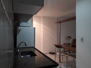 a kitchen with a refrigerator and a table with chairs at Suíte aconchegante no Centro de Campos WIFI Liberado in Campos dos Goytacazes +9 photos