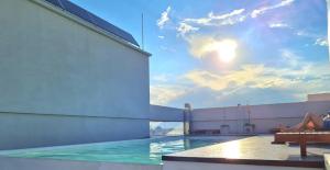 une femme assise sur le toit d'un immeuble avec piscine dans l'établissement Aires de Capital Depto, à Salta