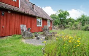 a red building with chairs in front of a yard at Gorgeous Home In Vittsj With House A Panoramic View in Vittsjö