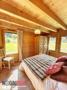 ムジェーヴにあるChalet Du Pont D Arbonの木製の部屋にベッド1台が備わるベッドルーム1室があります。