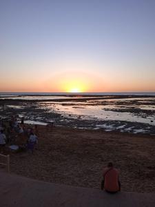 a group of people sitting on the beach watching the sunset at Nuevo Jerez in Jerez de la Frontera