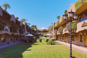 Suites Layfer, Córdoba, Veracruz, México في كوردوبا: ساحة فندق مع ضوء الشارع في العشب