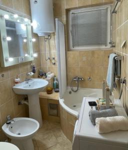 a bathroom with a sink and a toilet and a tub at Apartment Navigator's lodging in Kotor