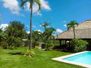 a resort yard with a swimming pool and a palm tree at Cabagnow Seaside Resort in Anda