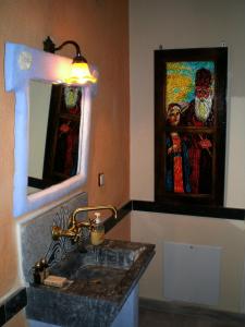 a bathroom with a sink and a painting on the wall at Petradi 1873 in Kalarrites +40 photos