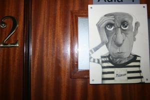a drawing of a man is hanging on a door at Golondrinas de Malaga "Apartamentos con mucho Arte" y terraza solarium en coliving in Málaga
