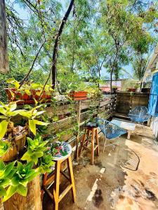um pátio com cadeiras e uma cerca com plantas em La Bocana Beach House em Santa María Huatulco