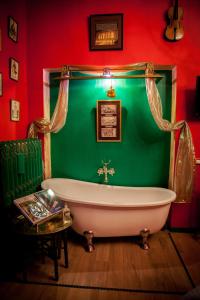 zieloną łazienkę z białą wanną i stołem. w obiekcie Repubblica Di Oz Rooms w mieście Varese