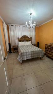 a bedroom with a bed and a chandelier at leroy place in Kingston