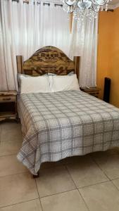 a bedroom with a bed with a checkered blanket at leroy place in Kingston