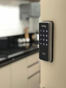a remote control hanging on a kitchen door at Loft Studio 204 no Kobrasol à 7km de Floripa in São José