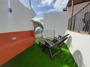 balcón con 2 sillas y césped verde en Vv Puerto del Trigo - Stella, en Alojera