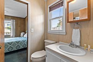 a bathroom with a sink and a toilet and a bed at Sunflower in Holden Beach +23 photos