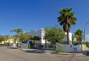 uma rua com uma cerca e uma palmeira em Appartamenti Torre Suda by Salento Affitti em Torre Suda