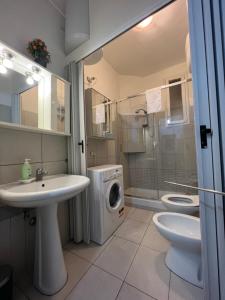 a bathroom with a sink and a washing machine at La Nova apartment in Naples