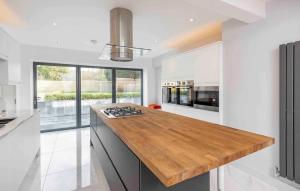 a kitchen with white walls and a wooden counter top at Love island style Mansion, Hot Tub, Sauna, Games room, themed rooms, bar, sleeps 24 in Saltford