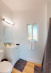 a white bathroom with a toilet and a sink at The Heathercliff in Malibu
