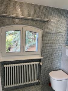 a bathroom with a toilet and a window at Room with 360° view overlooking Lake Geneva and Alps in Puidoux