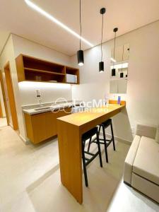a kitchen with a wooden table and a sink at Apartamento em Resort - Premium in Salinópolis