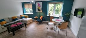 uma sala de estar com um sofá, uma mesa e cadeiras em Fab 2bedroom apartment- Free parking, 5mins from city centre, Portland Rd NE2 1DJ em Newcastle upon Tyne