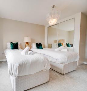 a bedroom with two beds and a large mirror at TALLEST BUILDING IN THE CITY CENTRE SLEEPS 5 incredible city mountain and Lagan views in Belfast